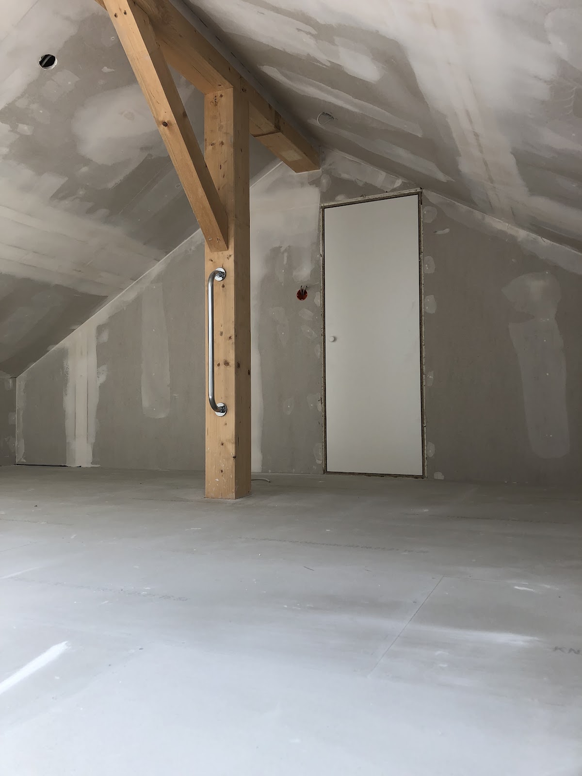 Fertig verputzter Spitzboden mit weißer Tür