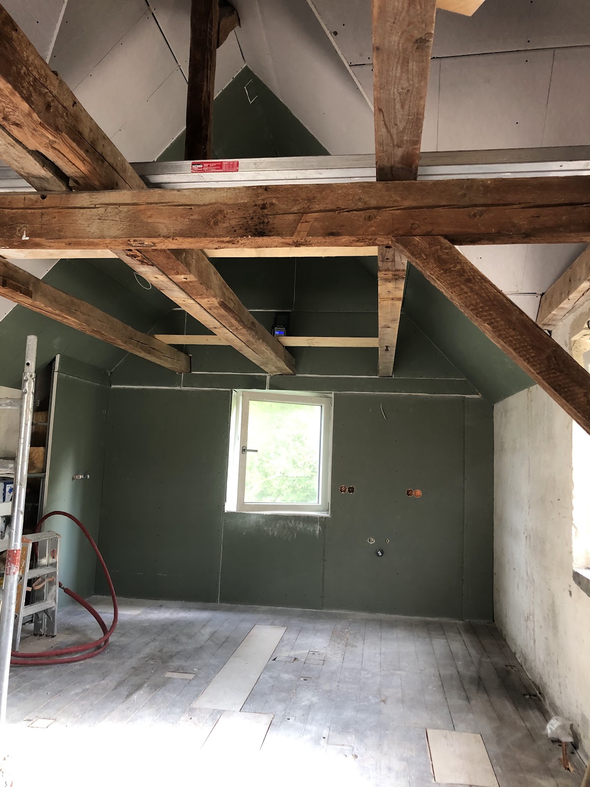 Raum mit imprägnierten Trockenbauplatten und Sichtbalken am Fenster
